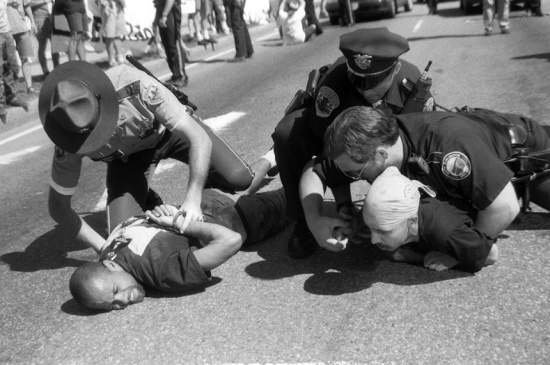 Two protesters are arrested attempting to blockade President Bill Clinton’s motorcade during the National Governors’ Association Conference in Burlington, VT in 1995.  They were protesting to draw attention to the impending execution of political prisoner Mumia Abu-Jamal.